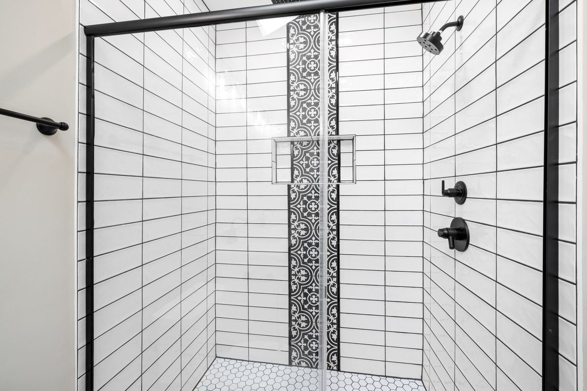 Douche carrelée dans une petite salle de bain rénovée