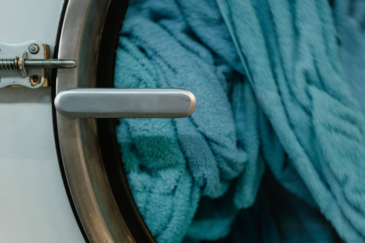 Hublot ouvert d'un lave-linge avec du linge