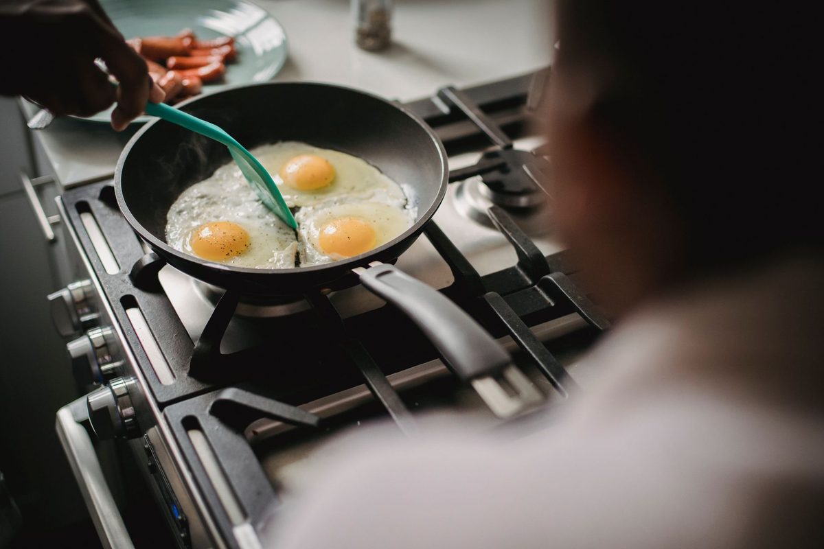 Œufs cuits dans une poêle sur une plaque de cuisson