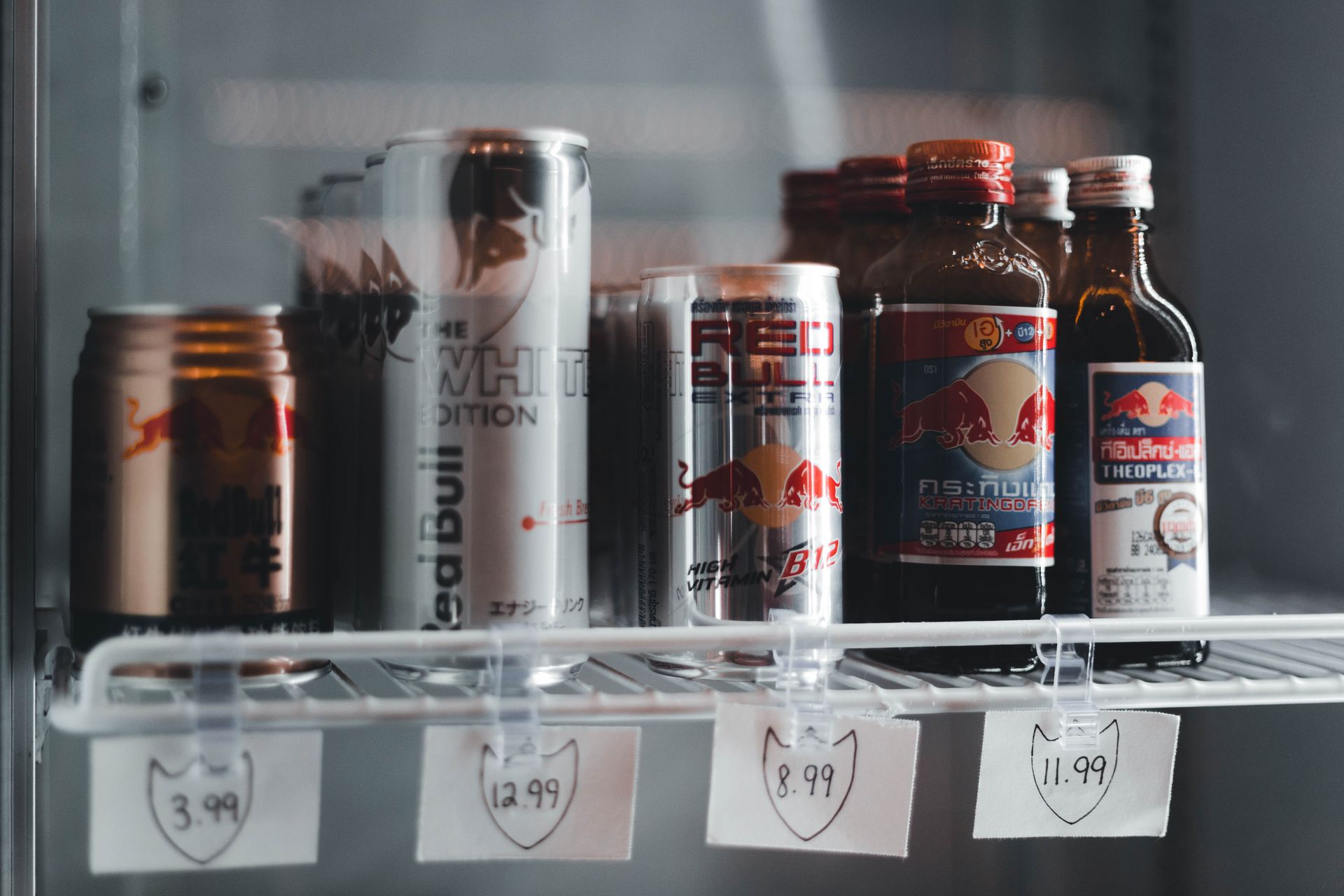 plusieurs canettes de boissons énergisantes en réfrigérateur avec étiquettes de prix