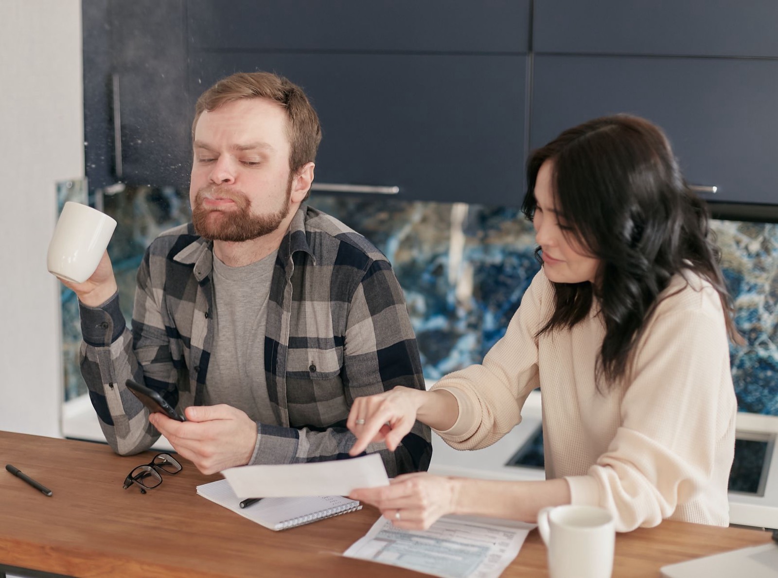 femme qui compare des factures d'assurance à sa table de cuisine