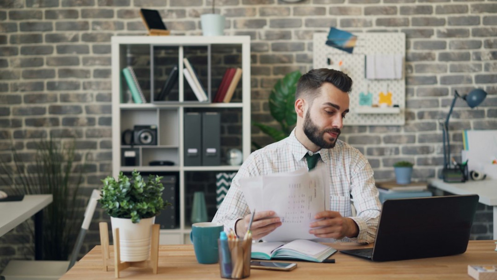Employé vérifiant une facture d'électricité professionnelle sur son bureau