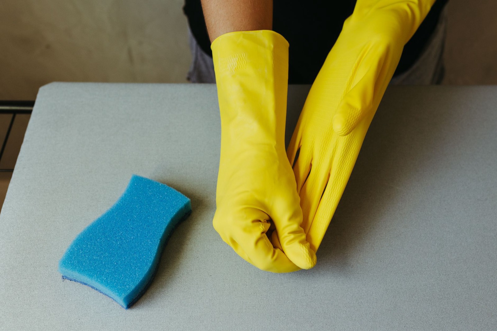Gants et éponge posés sur une checklist de ménage dans une cuisine